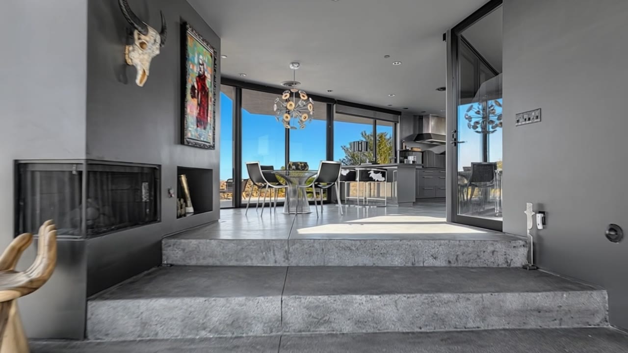 Modern concrete-and-glass desert home with an open kitchen and walls of windows